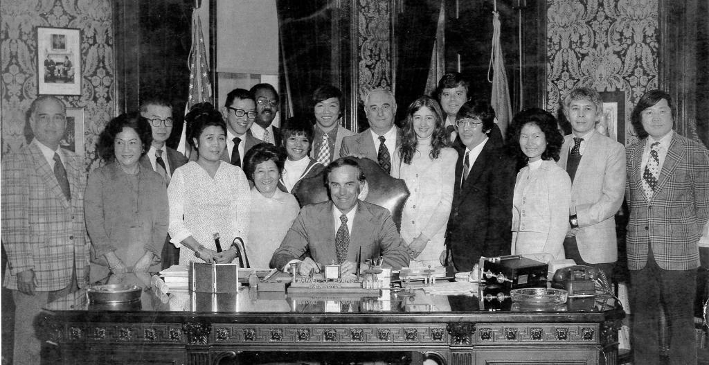 Dan Evans signing a bill with people around him.